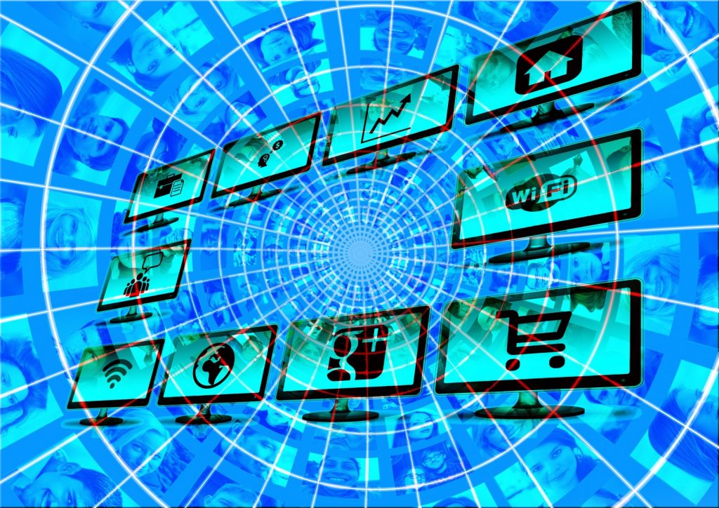 Un collage numérique composé de diverses icônes liées à la technologie et à Internet, notamment des graphiques, des réseaux Wi-Fi, des paniers d'achat et des logos de réseaux sociaux, disposés en spirale sur un fond de nombreux visages humains superposés. La palette de couleurs bleues globale suscite la question : pourquoi faire de la communication numérique ?